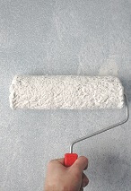 Image of a paint roller rolling on a wall