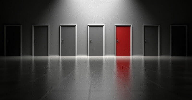 An image showing several doors, all gray except one is red